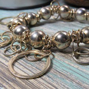 Gold Tone Bead Stretch Bracelet With Multiple Ring Dangles